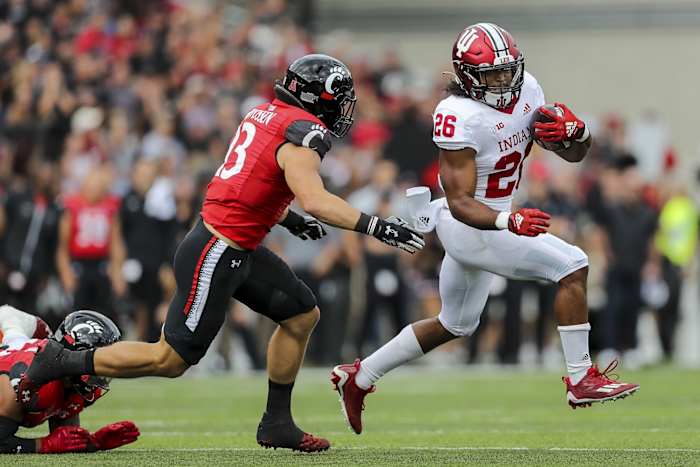 Indiana Hoosiers running back Josh Henderson (26) runs with the ball against Cincinnati Bearcats linebacker Ty Van Fossen (13) in the first half at Nippert Stadium.